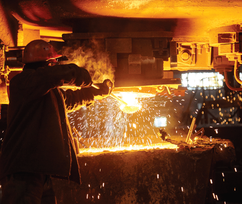 A man in a steel plant relies on non-flammable hydraulic fluid to lower the fire risk.